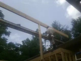 Carpenter setting a ridge beam over a new addition frame — Ice Dam Removal by Roofing Brothers in Fairless Hills