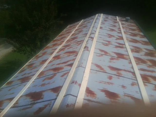 Rusted metal roof panels with new wood purlins before replacement — Storm Damage Roof Repair in Fairless Hills by Roofing Brothers