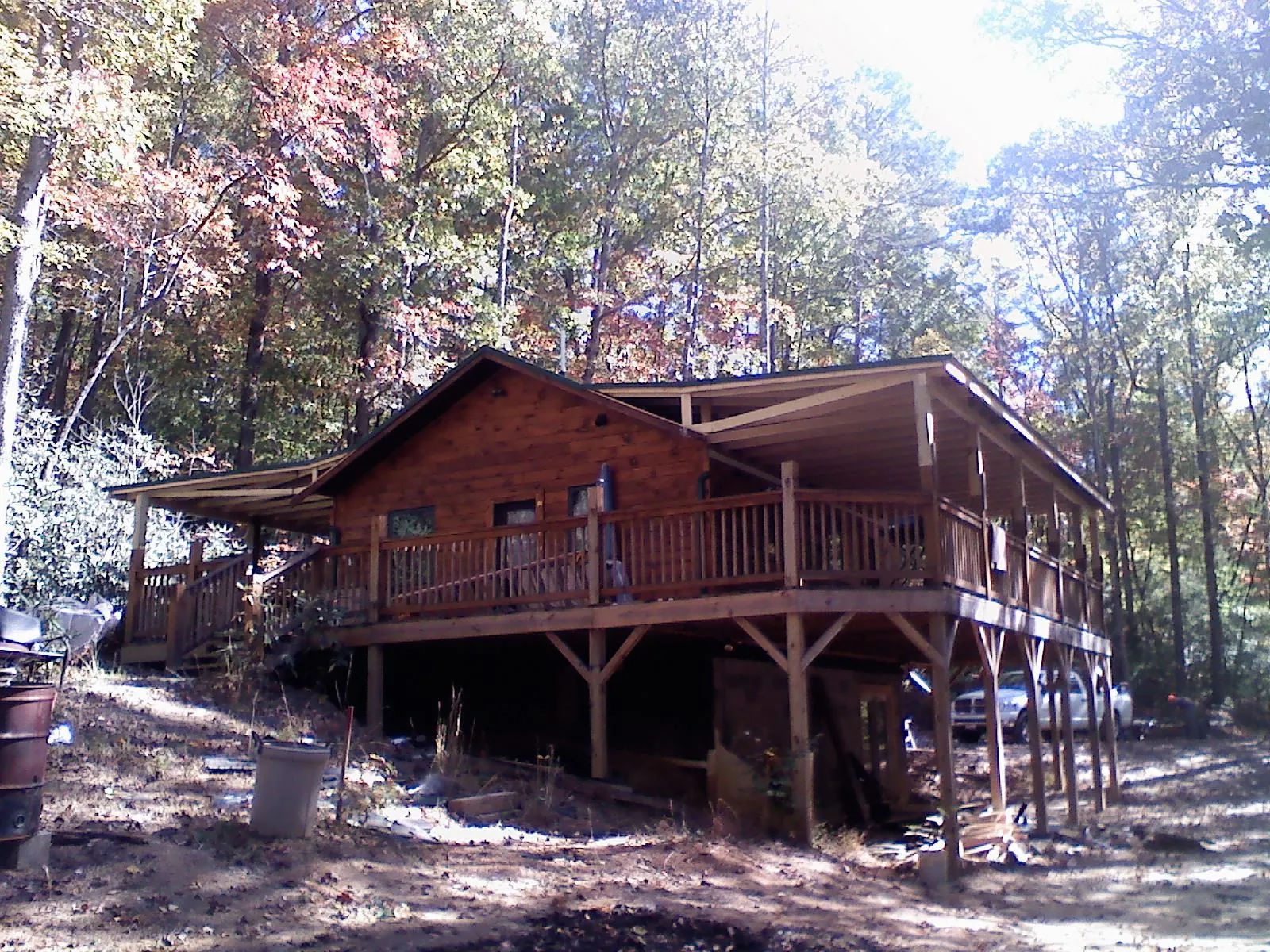 Log cabin with a wraparound porch and metal roof in the fall in Fairless Hills