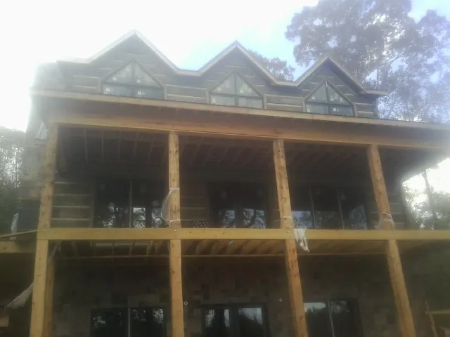 Dormers and porch framing on a large log home under construction — Roof Coating work by our crew in Fairless Hills